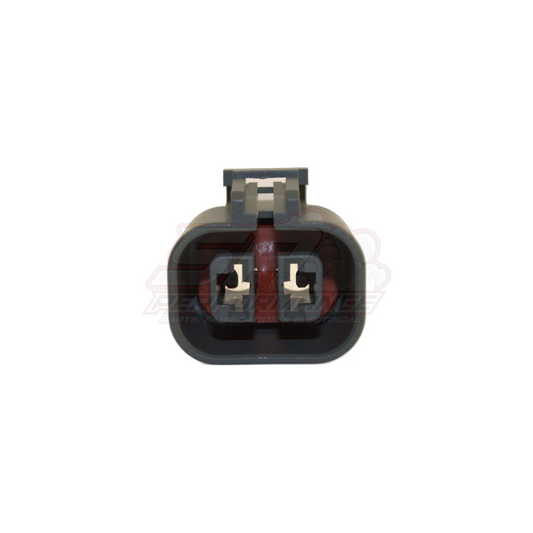 Front view of 2-pin grey alternator connector housing showing two female terminal slots with metal contacts and locking tab
