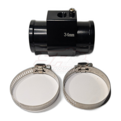 Black anodised aluminium 34mm coolant hose adapter with 1/8 NPT sensor port and silver bleed screw, shown with two stainless steel hose clamps