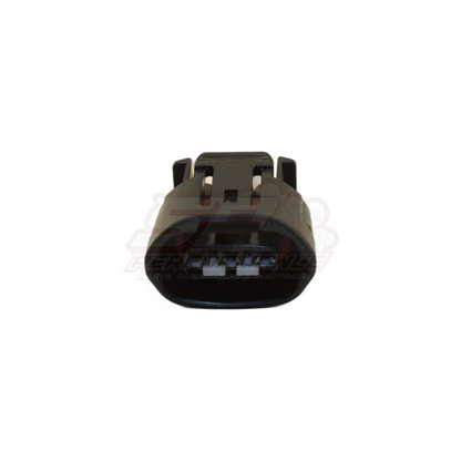 Grey Denso 3-pin alternator connector front view showing oval housing with three terminal slots and mounting tabs