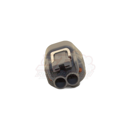 Angled rear view of 2-pin Denso left guide connector housing showing grey body, left-side wire entry ports and white locking clip