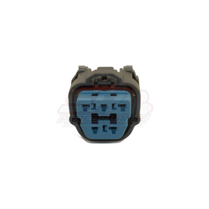 Front view of GM 5-pin connector showing grey housing with locking tabs and blue insert with five terminal cavities and red seal