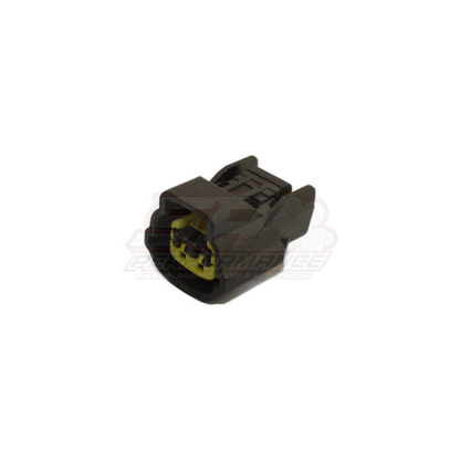 Angled view of 2-pin grey Nissan connector housing showing yellow terminal retainers and locking tabs for coolant temp sensor and fuel pump module
