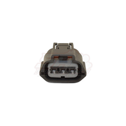 Front view of grey 3 pin Nissan ignition coil pack and TPS connector showing housing with locking tab and terminal cavities