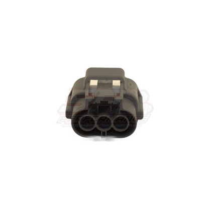 Front angled view of 3-pin Nissan ignition coil and TPS connector showing grey housing with metal locking tabs and three circular terminal cavities