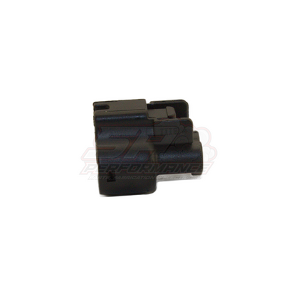 Black 2-pin Toyota Denso push-in connector housing angled view showing locking tab and terminal chamber openings